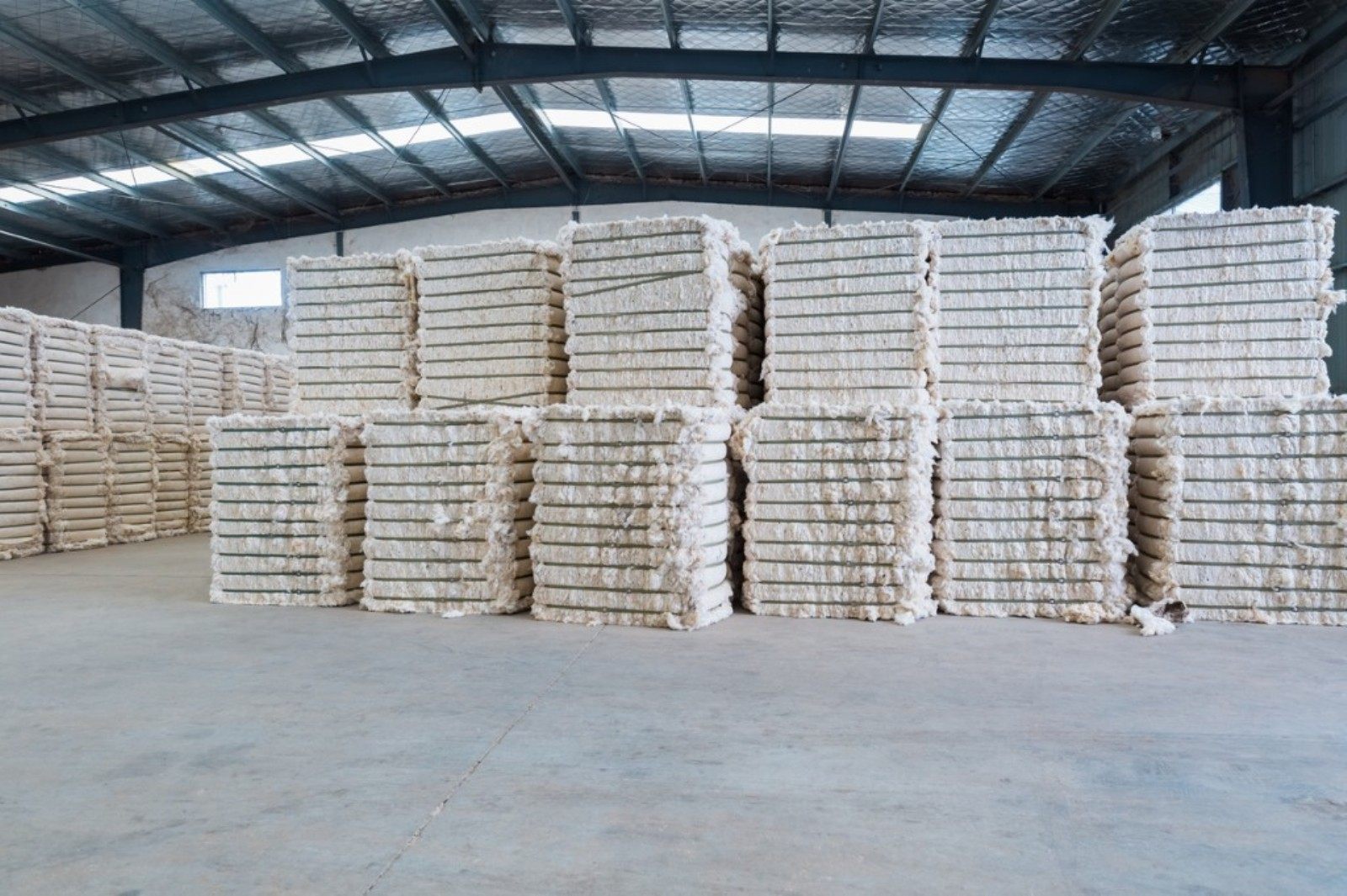 Stacked cotton fibre bales in a warehouse